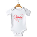 Flat mockup of the First Valentine's Day name design on a short-sleeve baby vest