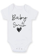 Flat mockup of the baby surname heart design on a short-sleeve baby vest