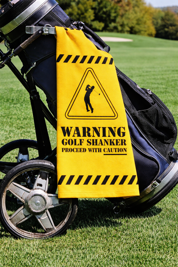Funny golf shanker towel with Warning Golf Shanker Proceed With Caution, clipped to a golf bag