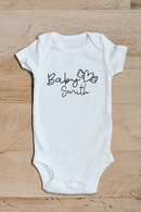 Baby surname heart wings baby grow showing the printed design on the front