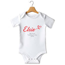 Flat mockup of the My First Valentine's Day design on a short-sleeve baby vest