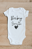 Baby surname heart baby grow showing the printed design on the front