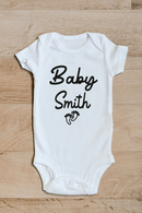 Baby surname footprints baby grow showing the printed design on the front