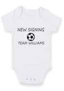 Flat mockup of the new signing design on a short-sleeve baby vest