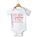 Flat mockup of the Our First Valentine's Day family design on a short-sleeve baby vest
