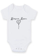 Flat mockup of the baby name balloon design on a short-sleeve baby vest