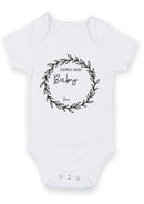 Flat mockup of the baby coming soon flower design on a short-sleeve baby vest