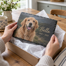 Personalised pet memorial slate plaque being lifted from a gift box on a kitchen table