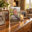 Memorial acrylic photo plaque on a sideboard among family photos and a candle