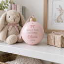 Baby's first Christmas bauble on a nursery shelf with a knitted bunny