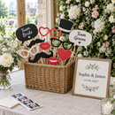 Basket of personalised photo booth props on a wedding photo booth table