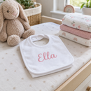 Personalised baby bib with the name Ella on a nursery changing unit