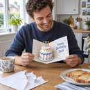 Man opening a personalised pop-up 3D birthday card at the breakfast table