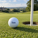 Personalised golf ball printed with the name Tom on a putting green