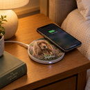 Personalised wireless charging pad charging a phone on a bedside table