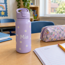 Personalised kids school water bottle with the name Mia on a classroom desk