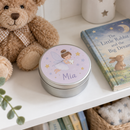 Personalised tooth fairy tin with the name Mia on a nursery shelf beside a teddy