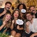 Friends at a birthday house party posing with personalised photo booth props