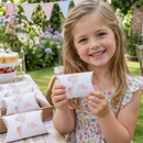 Personalised pillow treat boxes held by a child at a garden party