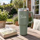 Personalised 40oz tumbler with handle with the name Olivia on a garden patio table