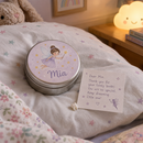 Personalised tooth fairy tin with the name Mia on a child's pillow at bedtime
