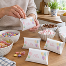 Personalised pillow treat boxes being filled with sweets in a kitchen