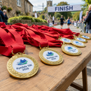 Printed medal inserts fitted in race medals at a finish line