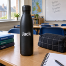 Personalised stainless steel water bottle with the name Jack on a school desk