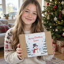 Child holding a personalised selection box sleeve with her name