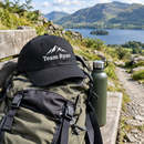 Personalised cap resting on a rucksack beside a hiking trail