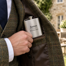 Personalised hip flask with the name James in a tweed jacket pocket