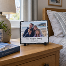 Personalised photo slate, on a wooden bedside table beside a lamp and a book in a calm UK bedroom