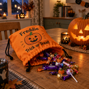 Personalised trick or treat bag spilling sweets beside a carved pumpkin