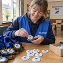 Printed medal inserts being fitted into medals by a club volunteer