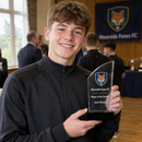 Acrylic club award trophy held by a young winner