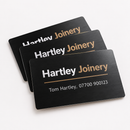 Metal business cards on a white background, showing an example personalised design