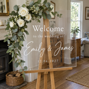 Close-up of a personalised acrylic wedding welcome sign with flowers