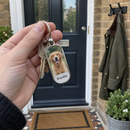 Personalised photo keyring: a hand holding house keys on a personalised metal oblong photo keyring showing a photo of a golden retriever and the name 'Bramble'