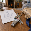Personalised bottle opener keyring: a Father's Day gift scene on a wooden table with a personalised 3-in-1 nail clipper keyring showing a photo of two children and the text 'Best Grandad'