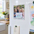 Personalised photo fridge magnet: glass photo magnet of grandchildren with the text 'Nana's Favourites' holding a child's drawing on a family fridge