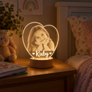 Personalised LED acrylic night light glowing on a child's bedside table