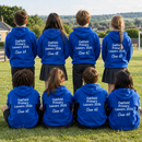 Year 6 pupils wearing matching school leavers hoodies with names on the back