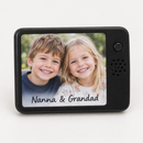 Personalised musical photo magnet: a personalised black musical fridge magnet with a rectangular photo panel printed with a photo of two smiling young children and the name 'Nanna & Grandad'