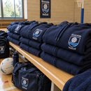 Stack of personalised team hoodies with club logo in a sports hall