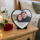 Personalised heart photo slate, on a bedside table with a single red rose and fairy lights in a cosy bedroom