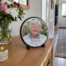 Personalised round photo slate, on a hallway console table in a UK home next to a vase of fresh flowers