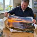 Personalised metal photo print, being unwrapped by a smiling man in his 50s at a kitchen table on Father's Day