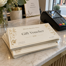 Numbered gift vouchers beside a card reader at a till