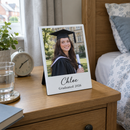 Personalised desk photo panel, on a bedside table next to an alarm clock and a glass of water