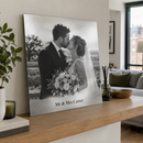Personalised silver metal photo print, leaning on a wide oak shelf in a stylish modern UK apartment